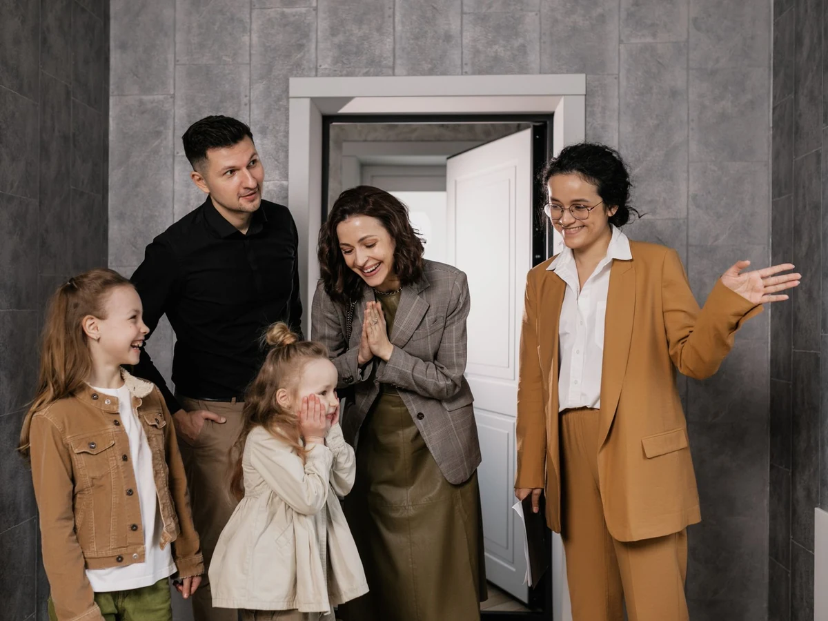 Asesora inmobiliaria mostrando una casa a una familia